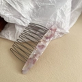 Detail view of acetate comb with pink marble pattern and dark grey metal teeth - Light Purple Marble