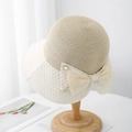 Detail of khaki straw weaving and cream embossed brim with a large bow and gold metal accent - Dot Double Bow Bucket Hat / Off-white