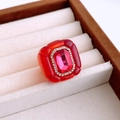 Nahaufnahme eines roten Vintage-Harzrings mit weißen Strasssteinen in einer Schmuckschatulle - Rot - Rosérot