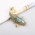Teal crystal fish figurine with gold foil accents on a clean white surface - Amazonite