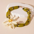 Detail der olivgrünen Harzperlen und eines großen weißen Blumenanhängers am Choker - Weiße Blumen-Bambus-Gelenk-Halskette