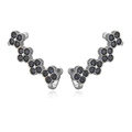Detailed macro view of silver flower ear climbers with deep blue round-cut crystals - Platinum Blue Zirconia