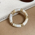 Detail of acrylic marble texture beads and gold metal spacers on an elastic bracelet - Round Splicing / Off White