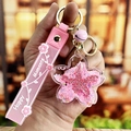 Pink cherry blossom keychain featuring sakura floating glitter and golden bell pendant - Pink