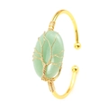 Detail of tree of life wire-wrapped green stone on a gold bohemian cuff bracelet - KC Gold & Green Aventurine