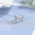 Collana a farfalla in argento con zirconi scintillanti su sfondo azzurro chiaro - Oro Bianco