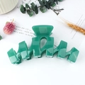 Glossy peacock green wavy hair claw clip for women on a natural decorative background - Jade Green