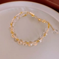 Dettaglio macro del bracciale in filo d'oro intrecciato a mano con perle e catenella - Bracciale di Perle Farfalla Bianca