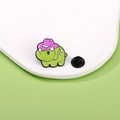 Niedliche grüne Emaille-Brosche in Dinosaurier-Form mit rosa Hut und schwarzem Verschluss - Hellgrüner Triceratops