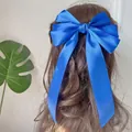Detail einer großen blauen Satinschleife mit langen Bändern am Haar eines Models - Königsblau