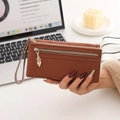 Macro view of brown lychee pattern leather wallet featuring a gold leaf-shaped zipper pull - Litchi Grain Brown