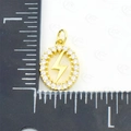 Oval gold lightning bolt pendant with clear zircon frame shown against a ruler for size - Flash