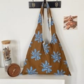 Detail of blue floral canvas tote bag showing soft fabric texture and large capacity - Brown