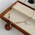 Dettaglio del ciondolo a croce in legno con inserto in argento su cordino in pelle in scatola - Collana Caffè / caffè