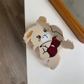 Close-up of a beige puppy hair claw clip with a red bow tie on a white surface - Rabbit & Cherry