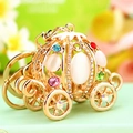 Macro shot of golden pumpkin carriage keychain with white opal and colorful rhinestones - Cinderella Pumpkin Carriage White