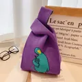 Purple knitted wrist bag with a cute teal bird illustration for a casual look - Purple Crooked Head Duck