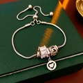 Detail eines verstellbaren Silberarmbands mit Zirkon und Herzanhänger auf grüner Box - Silber