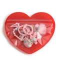 Red heart-shaped resealable bag containing pink kids hair clips and beaded bracelet - 17x20cm / Red