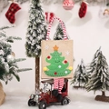Weihnachts-Geschenkbeutel aus Jute mit Tannenbaum und gestreiften Beinen auf rotem Auto - Weihnachtsbaum