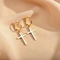 Close-up of polished gold-plated cross charms on silk fabric for a luxury earring detail - Cross / Gold
