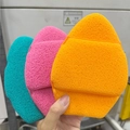 Three egg-shaped facial sponges in orange, pink, and blue with textured cleaning grooves - Flat Bottom Jumbo Rose Red / Rose Red