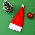 Primo piano di un mini cappello di Babbo Natale rosso e bianco su sfondo festivo - 6*12 Cm (set Di Tappo Per Bottiglia Di Vino Coltello E Forchetta)