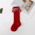 Vue détaillée de chaussettes de Noël rouges pour enfants avec nœud à carreaux sur fond blanc - Xs 0-1 Ans / Rouge Chaud