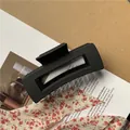 Close-up of matte black rectangular hair claw clip with geometric hollow design - Medium (approx. 8.5cm) / Black