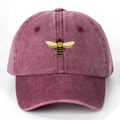 Detailed close-up of purple washed cotton baseball cap featuring embroidered bee pattern - One Size / Burgundy