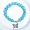 Blue turquoise bead bracelet featuring a silver butterfly charm on a white background - Blue Turquoise Butterfly Charm