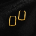 Close-up of golden rectangular hoop earrings with hammered texture on black silk fabric - Rectangle Embossed / Gold