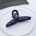 Close-up of deep blue matte hair claw clip with twisted cross design on a white plate - Matte Cross Navy Blue