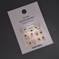 Close-up van gouden nail art bedeltjes met smaragdgroene kralen en strass op displaykaart - MJ-029 Goudstempelen / Goud
