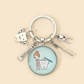 Detail of dentist keychain with silver charms of tooth, toothpaste and toothbrush - Style 5 (Brushing Teeth)