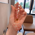 Close-up of sparkling rhinestone heart keychain with gold ring in a lifestyle setting - Red