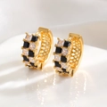 Makroaufnahme goldener Creolen mit schwarz-weißem Schachbrettmuster aus Zirkonia - Zirkonia-Schachbrett-Stil / Gold
