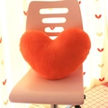 Modern orange heart-shaped plush throw pillow placed on a minimalist white chair - Orange Heart