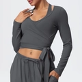 Dettaglio del top sportivo a incrocio grigio scuro con lacci in vita e pantaloni da yoga - S / Grigio Vulcanico