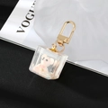 Macro detail of transparent resin cube pendant with pink bear and gold lobster clasp - Pink Bear