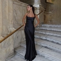 Elegantes schwarzes rückenfreies Satin-Maxikleid auf einer luxuriösen Marmortreppe - S / Schwarz