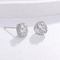 Macro shot of silver heart-shaped stud earrings with sparkling cubic zirconia on stone - Heart