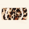 Detail of leopard print baby headband featuring bow design and white pom pom trim - Style B (Brown Black Leopard)