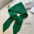 Detailed view of green knitted hooded scarf with ribbed texture on soft white fabric - Hat and Shawl Integrated Set / Green
