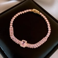 Detailed close-up of a pink oval zircon bracelet with a gold-plated link and clasp - Pink