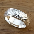 Hawaiian style silver floral ring with plumeria engraving on a dark wooden background - US 7 / White Gold