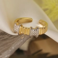 Makroaufnahme von vergoldetem Wellenring mit Zirkonia auf Seide und Glaswellen - Wellenreihen-Strass