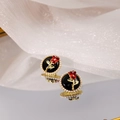 Close-up of vintage red rose earrings with black base and pearl border on white silk - Black Red Rose Pearl Border Studs