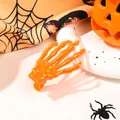 Detail of a bright orange skeleton hand hair clip on a festive Halloween spider web background - Orange (Integrated)