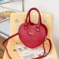 Borsa a mano rossa a forma di cuore con stampa coccodrillo e logo dorato su sedia - Borgogna